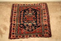 Front view of the handmade small rug showing full design and overall condition.