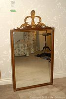 Full view of the rectangular wood framed antiqued mirror showing entire frame and reflective surface.