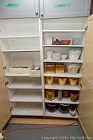 Full view of shelves showing multiple plant pots of various sizes and colors including white, terracotta, and gold-tone along with some decorative rocks.