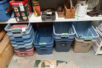 Multiple plastic storage bins stacked on shelving with labels marked Small, Medium, and Large. Bins are in blue, pink, beige, and other colors. Signs of wear visible.