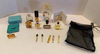 Full view of perfume assortment including bottles, sample vials, and black gift bag.
