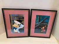 Two framed Mickey Mouse prints side by side showing artwork and frame details