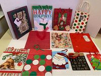 Overview of all 12 assorted holiday gift bags showing various festive designs including Santa, polar bear, dog with ornaments, polka dots, and numbered advent calendar style.
