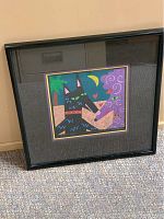 Framed artwork shown leaning against wall, entire frame and glass shown to display physical condition and size