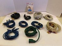 Overview of assorted coiled computer and audio cables with various colors and connectors on a white background.