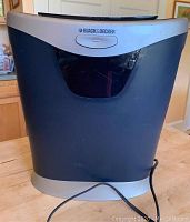 Front view of Black And Decker paper shredder showing brand name and shape with power cable attached.