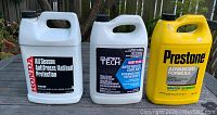 Front side of three automotive antifreeze coolant jugs from Honda, Super Tech, and Prestone.