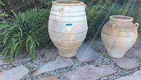 Full view of the large urn pot placed outdoors with garden plants around it