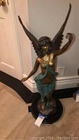 Front view of full brass angel statue on round base