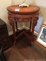 Full view of round wooden side table with carved legs and apron, showing overall condition and design.