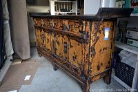 Side angled view of buffet showing distressed finish and raised panels
