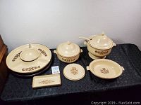 Top view of Pfaltzgraff Village Stoneware set including platter, covered dishes, plates, and butter dish.