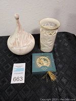 Photo of three items: Mt. St. Helens ash bowl with lid, white Leddon vase, and Lenox ornament box on black cloth.