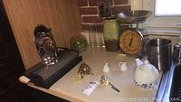 Wide view of lot including Salter scale, vase, teapot, shooters, brass turtle trinket box, owl hook, utensil holder and can opener