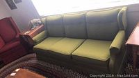 Front view of vintage green upholstered couch in living room