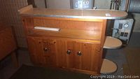 Full view of vintage wooden cabinet in basement with three lower doors and detached formica top