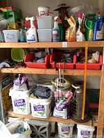 Wide shot of wooden shelves containing various gardening products including fertilizers, pest control products, glove packs, bird feeders, and pet waste containers
