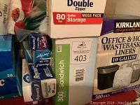 Boxes of storage bags including gallon size double zipper bags, sandwich bags, and some foil wraps.