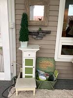 Shelf unit next to picnic basket and other items on porch