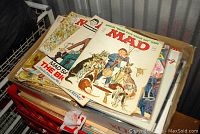 Photo showing a portion of the stacked MAD magazines with visible cartoon covers and different cover artwork.