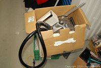 Rowenta steamer placed inside a cardboard box showing the unit, hose, and some missing parts.
