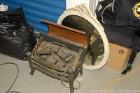 Overall view of Magicoal electric fireplace with faux coal logs and 22x25 oval framed mirror leaning behind it.