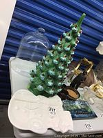 Photo of the green ceramic Christmas tree lamp with red bulbs, repaired base, alongside clear bell jar and white snowman platter on table