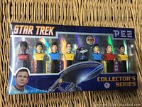 Front of Star Trek PEZ dispenser box showing 8 PEZ dispensers with Star Trek character heads and holographic Star Trek branding.