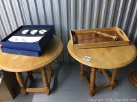 Top view of two round pine side tables next to each other, one holding a blue boxed Villeroy & Boch porcelain appetizer set and the other holding a wooden serving tray.