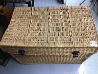 Wicker trunk rectangular shape, top closed, showing original metal latches and woven wicker texture.