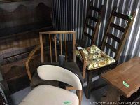 Five chairs arranged closely showing variety of styles and conditions in a storage setting.