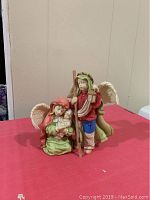 Front view of Mary holding baby Jesus and Joseph figurine standing with lantern and staff.
