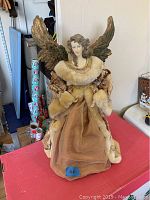 Full view of the 24 inch tall angel figurine with fabric and faux fur dressed gown and large decorative wings.