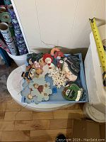 Overview of assortment of various hand painted wooden Christmas ornaments in a tray, including snowmen, snowflakes, Santa, reindeer, and other figures.