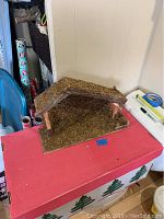 Full view of rustic handcrafted nativity set barn showing wood and moss construction