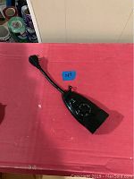 Black light timer with flexible neck on red surface, shows full length and design.