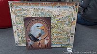 Two framed art pieces; foreground 3D eagle art, background illustrated map of Phoenix
