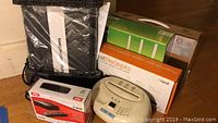Assortment showing router packaging, NeatReceipts box, RCA media player box, Secure-SHRED shredder