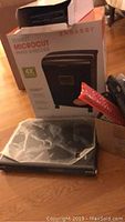 Photo of Embassy Microcut paper shredder in box with part of the laptop visible.