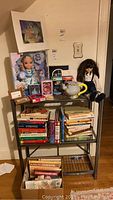 Wide view featuring origami shelf with dolls, cups, alarm clock, and books.