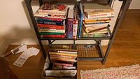Shelf and box full of assorted cookbooks and health books in mixed sizes and conditions.