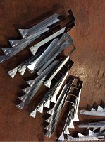 Photo showing a cluster of new metal joist hangers with multiple pre-punched holes.