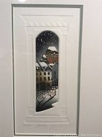 Full view of the framed art showing the window arch with urban snowy scene under starry sky.