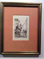 Full framed engraving print with salmon mat and visible signature on right bottom corner and title at bottom.