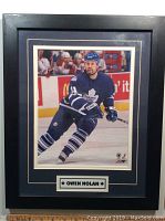 Full view of framed photograph of Owen Nolan skating in Toronto Maple Leafs jersey with name plaque.