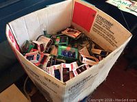 Cardboard box filled with multiple packages of colored Christmas light replacement bulbs