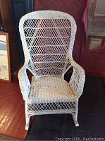 Front view of the white wicker rocking chair showing woven pattern and seat area