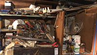 View of wooden tool chest with hand tools including hand saws, screwdrivers, files, hand plane, and other small tools packed inside and on top.