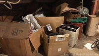 Boxes containing candle making supplies in a cluttered basement or storage area