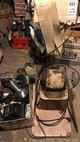 Photo of vintage electric appliances and grinding wheel in basement environment